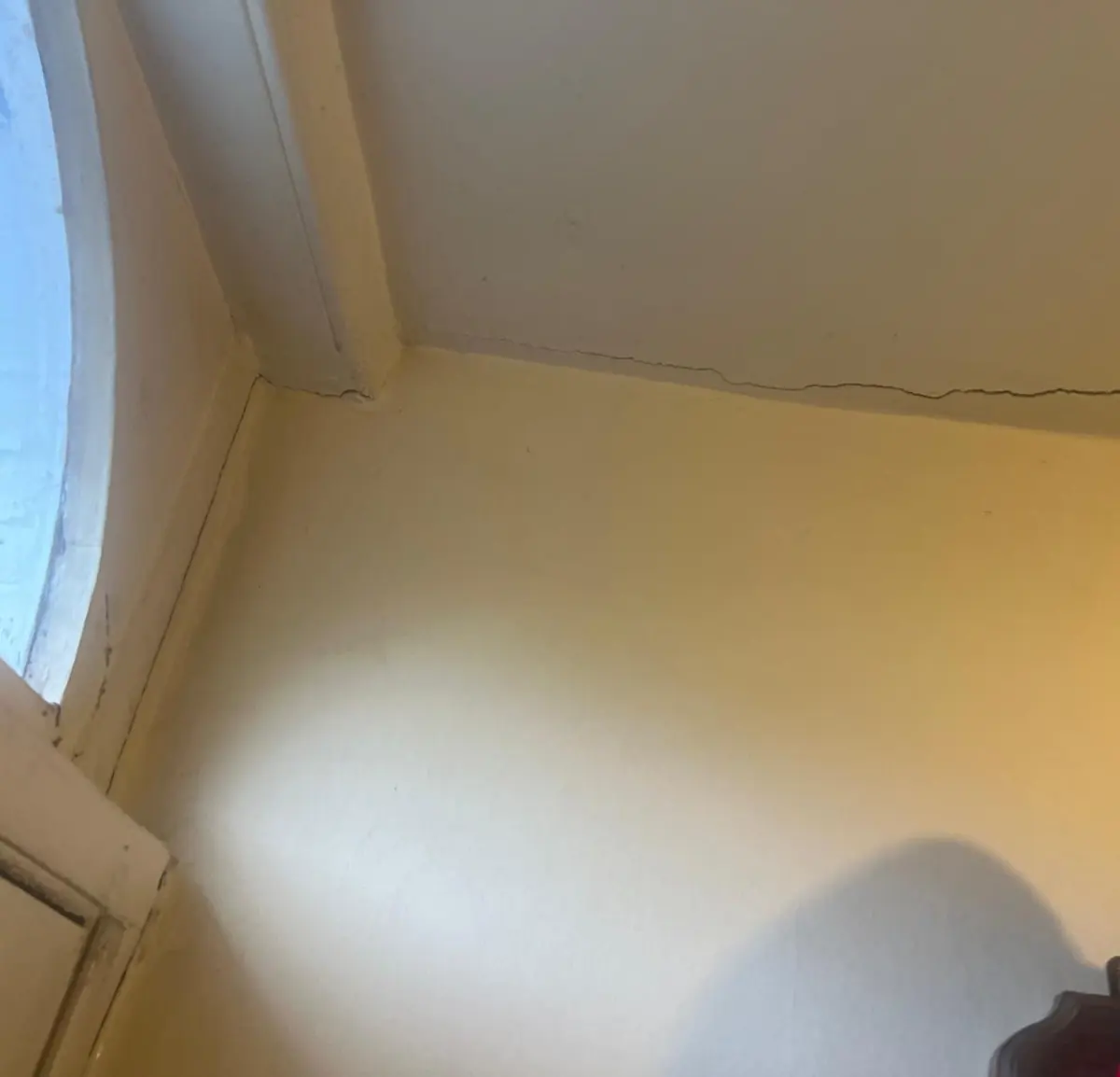 Crack along the wall/ceiling junction beside a window reveal, found during the structural inspection