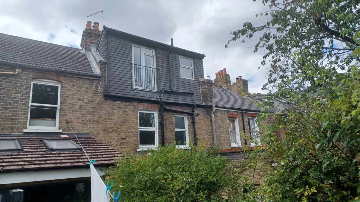 Rear of the London stock-brick terrace from the garden: tile-hung rear dormer with Juliet balcony, two-storey rear, existing single-storey rear roof with rooflights