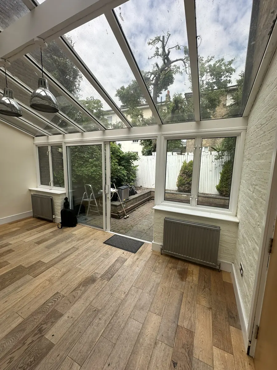 Glazed rear garden room of the mews house before the works