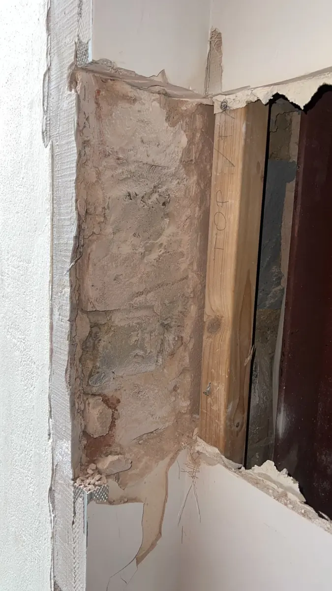 Opening-up inspection: masonry pier beside new timber packing and a red-oxide steel beam