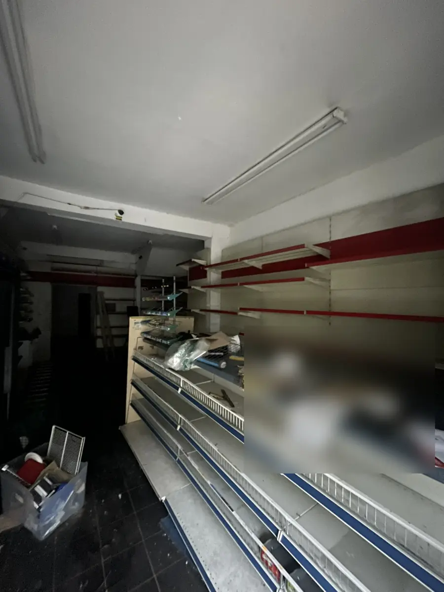 Interior of the vacant ground-floor shop unit with old shelving, before conversion