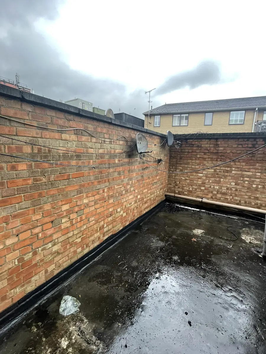 Flat roof over the rear of the shop with brick parapet walls