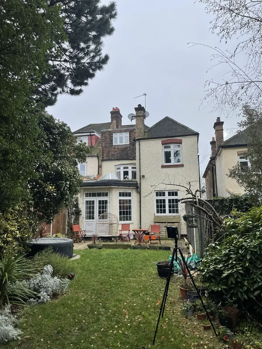 Rear elevation of the semi-detached house from the garden, laser-scanner tripod in foreground